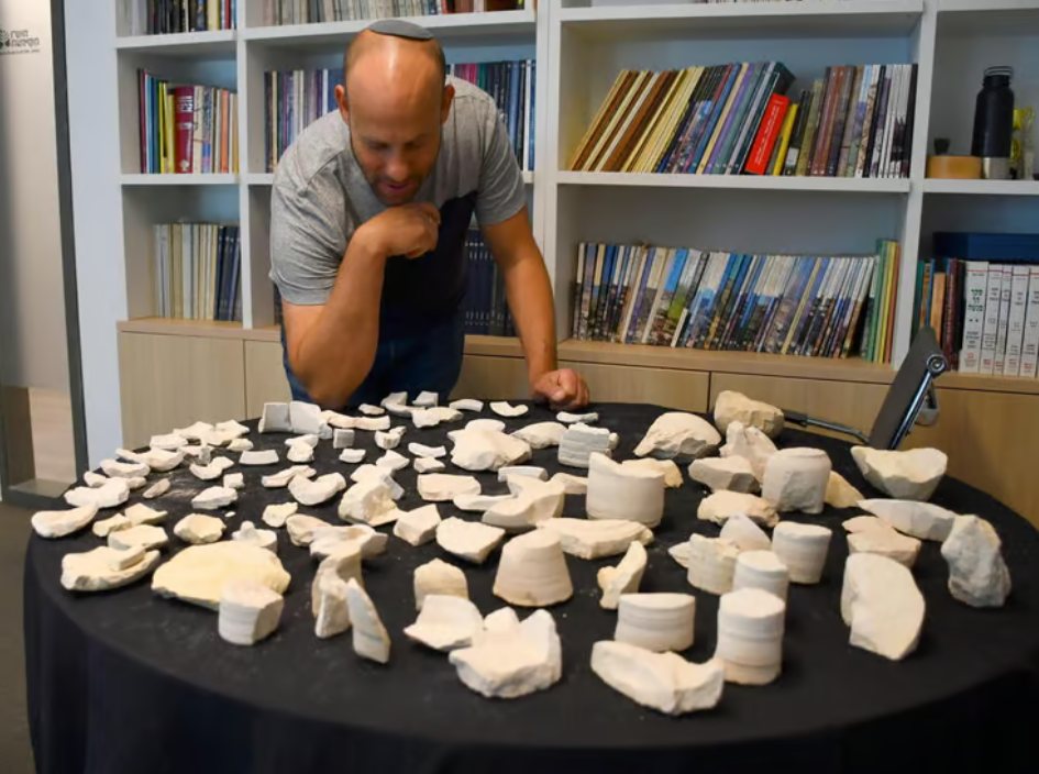 החוקר איתן קליין עם כמה מהפריטים שהתגלו (צילום: יולי שוורץ, רשות העתיקות)