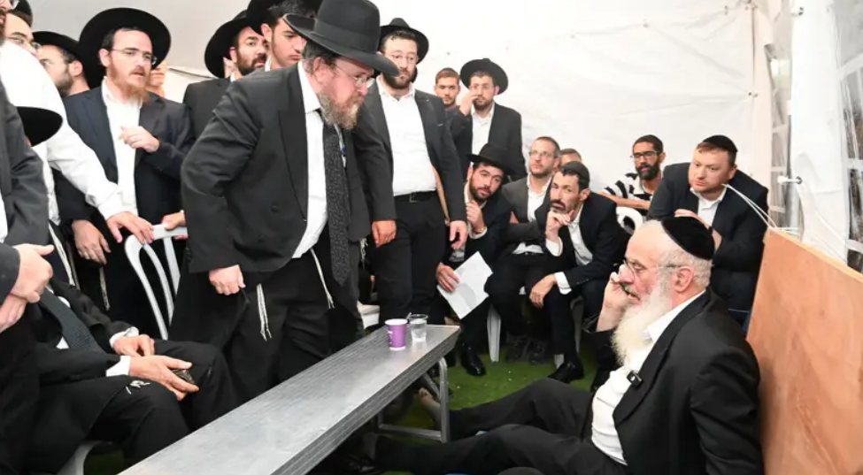 הגרמ"ה הירש מנחם טלפונית את הרב פייבלזון (עומד: בנו של הרב הירש) | שימוש לפי סעיף 27א