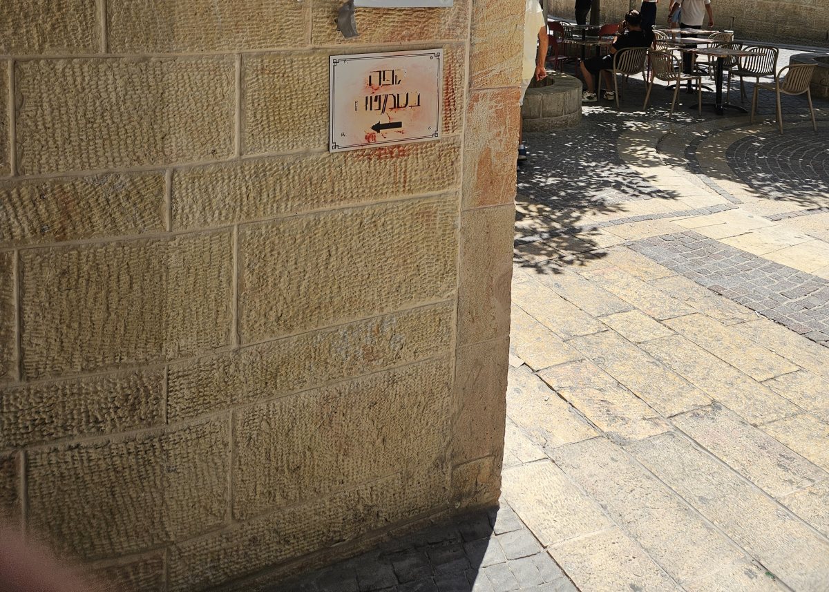 שלט, שהושחת על ידי מפגינים, עם שמו של בית הקפה | צילום: Pinhas stern ויקיפדיה