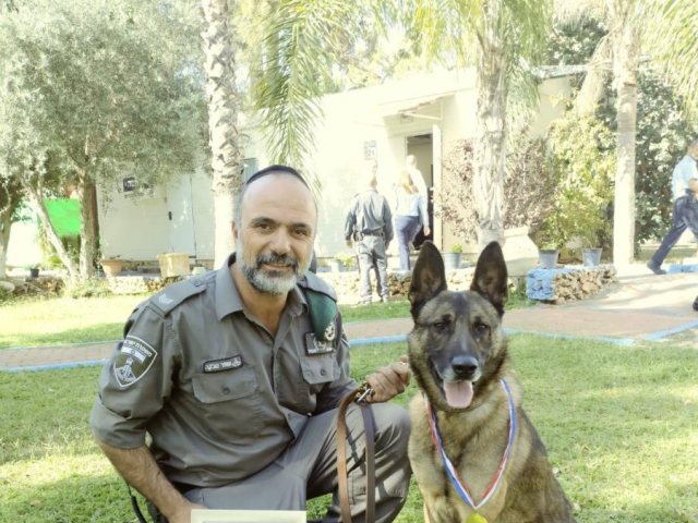 אחד מכלבני המשטרה שזכה במדליה לצד מפעילו | צילום: מג"ב